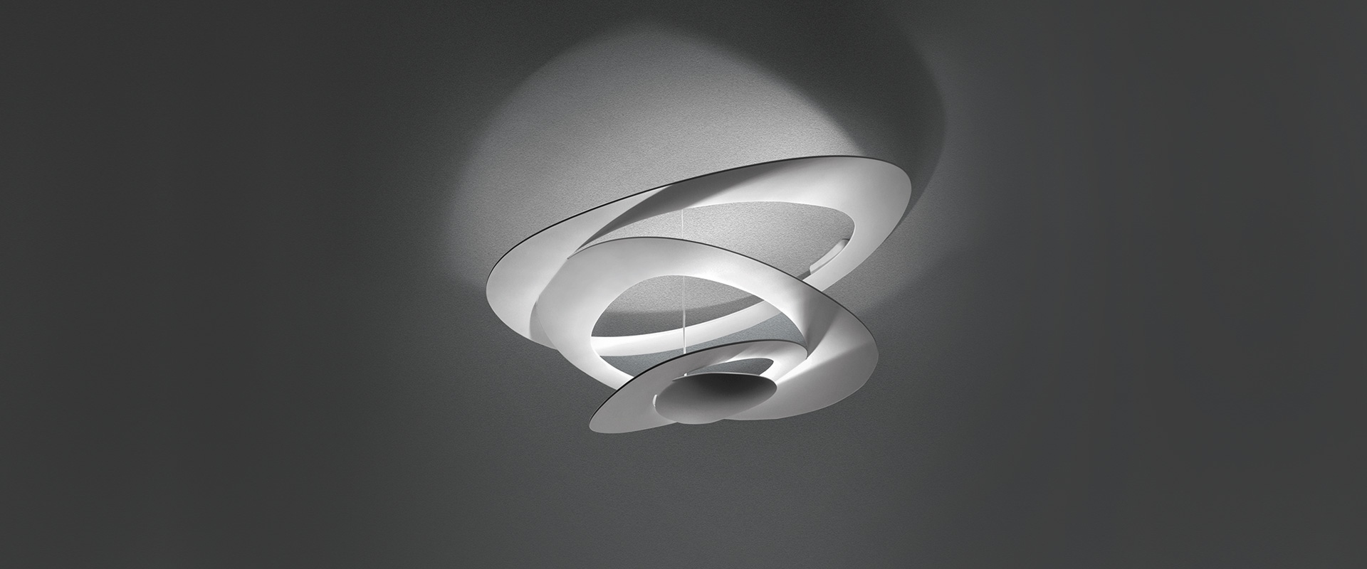 Artemide Pirce Soffitto ceiling lamp in gold finish, featuring a sculptural spiral aluminum shade casting upward light