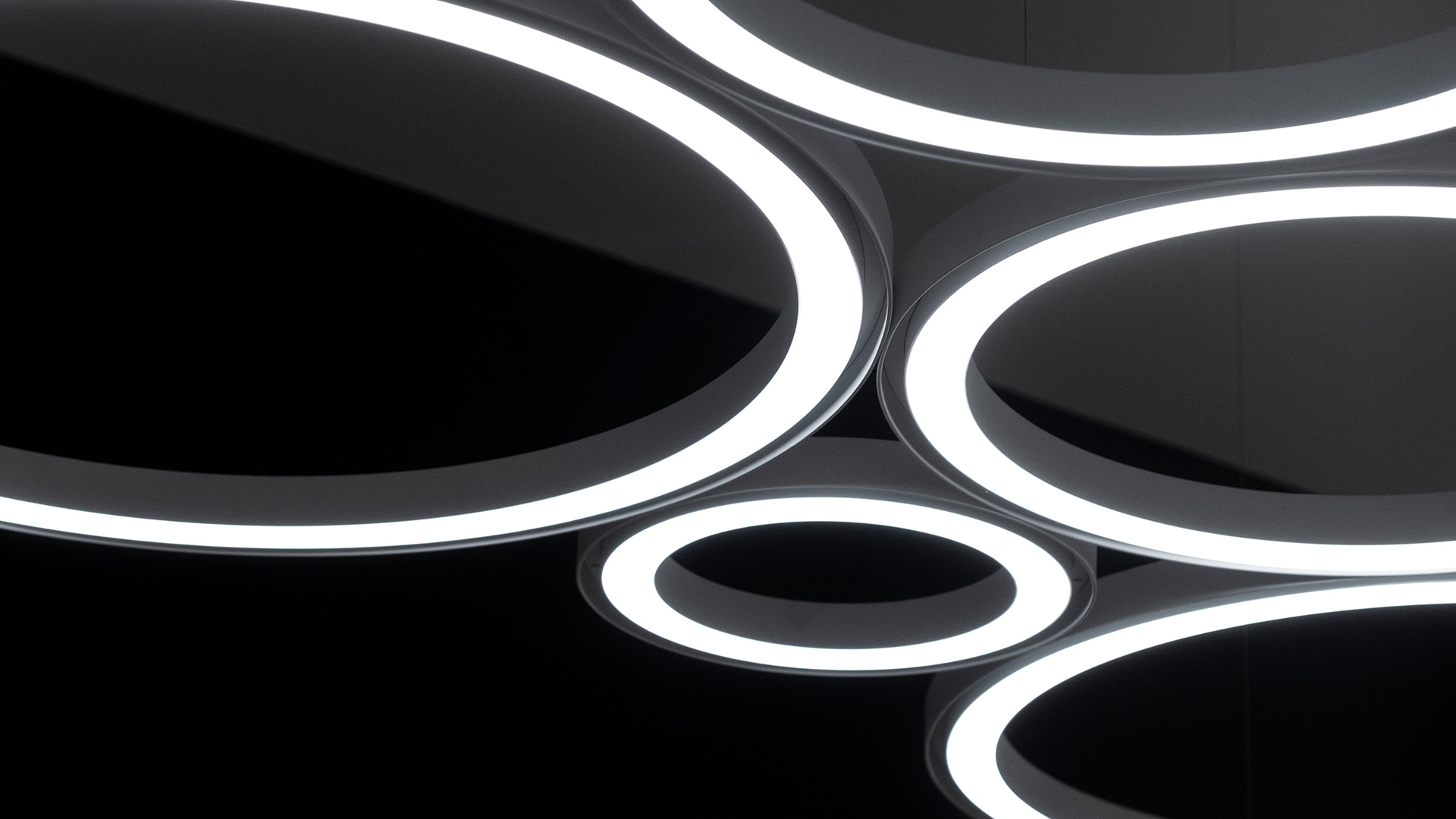 Lampada a sospensione Artemide Ripple con paralume cilindrico in tessuto bianco sospesa sopra un tavolo rotondo con piccoli oggetti decorativi