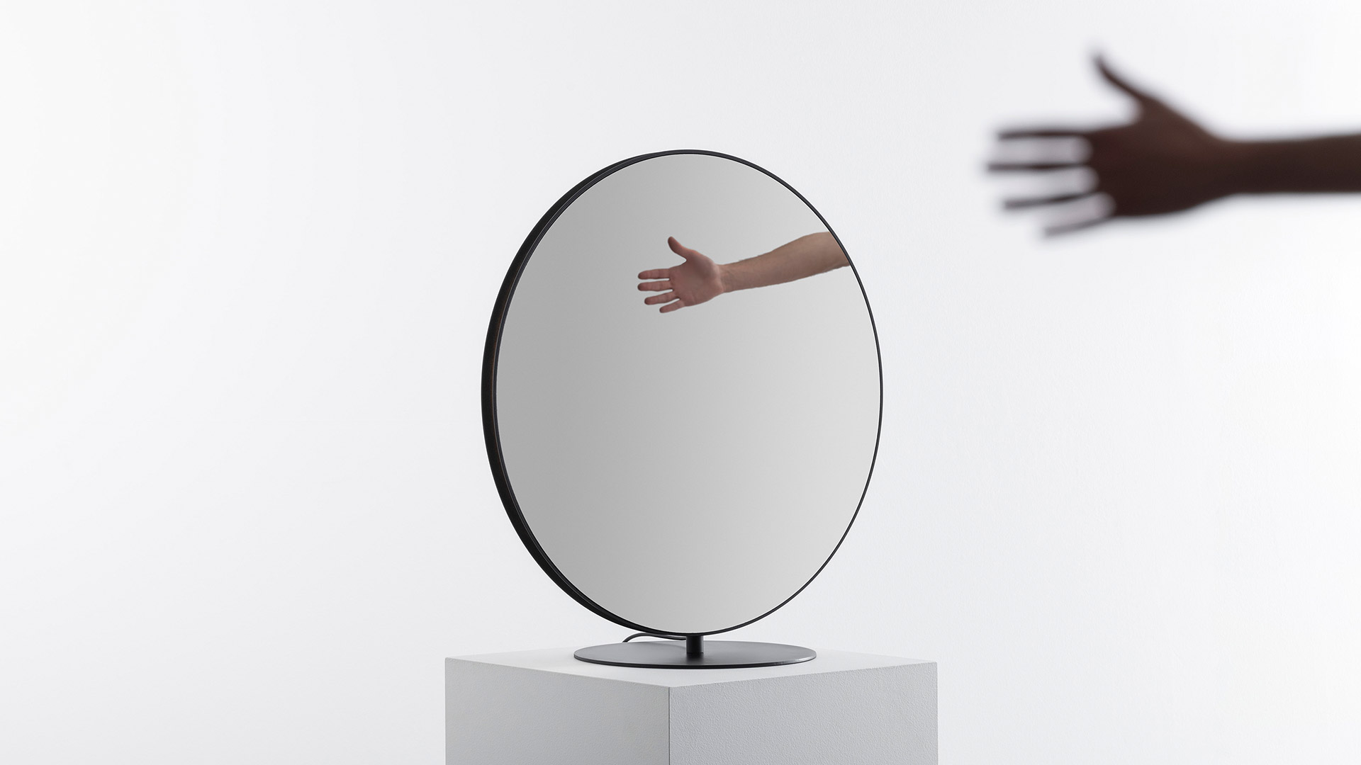 Lampada da terra circolare Artemide Se|eS con struttura in metallo scuro e illuminazione LED perimetrale calda, posizionata all'aperto su erba con sfondo di fogliame verde