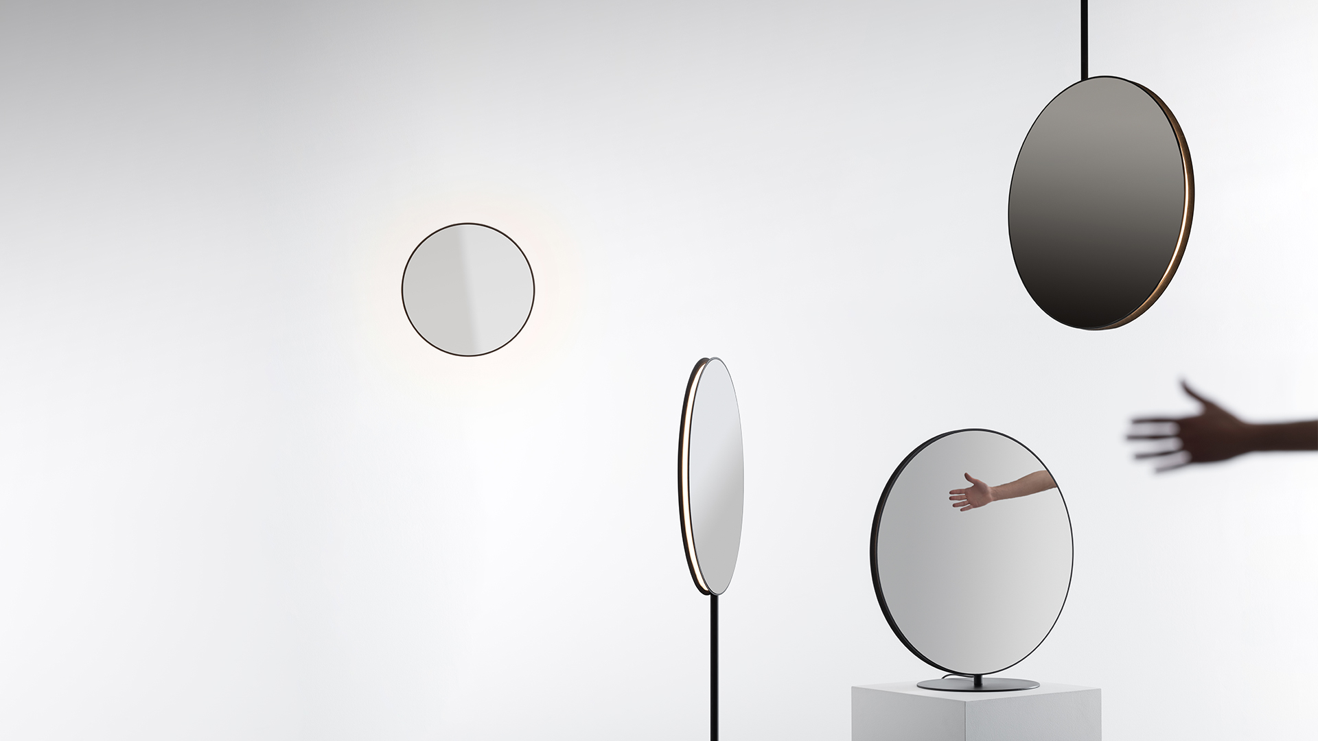 Lampada a sospensione Artemide Se|eS: diffusore circolare a disco scuro con bordo bronzo, sospeso da cavo nero a soffitto bianco