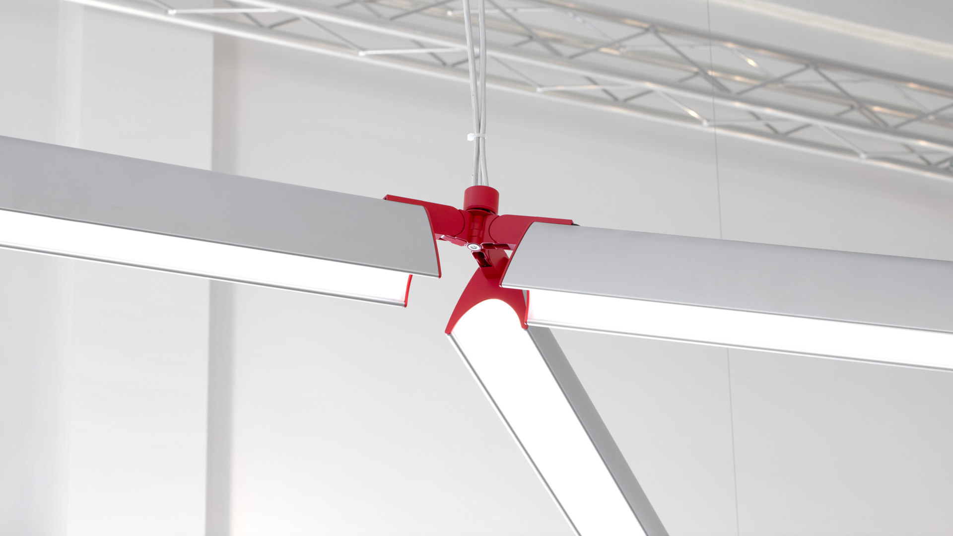 Artemide Series Y modular pendant light: yellow cross-shaped connector joining two linear LED profiles suspended by steel cables