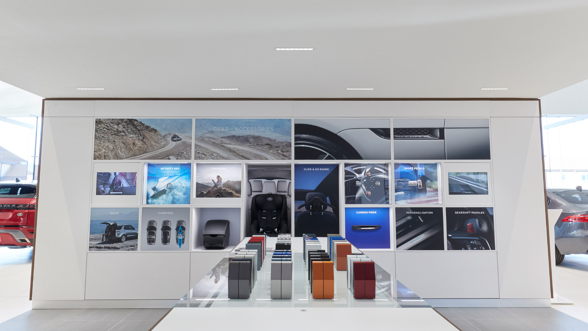 Dark showroom ceiling with Artemide Sharp recessed LED fixtures emitting cool white light, complemented by perimeter cove lighting.