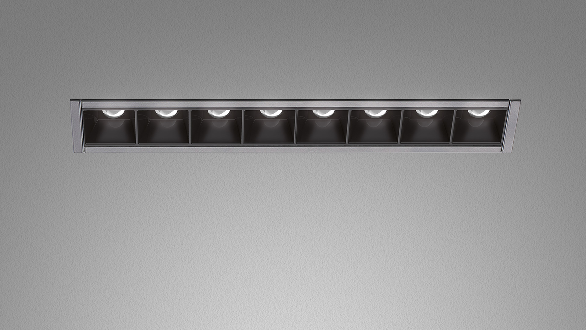 Artemide Sharp Refractive Emission: apparecchio da incasso lineare a soffitto con 8 celle quadrate nere e sorgenti LED in cornice argento