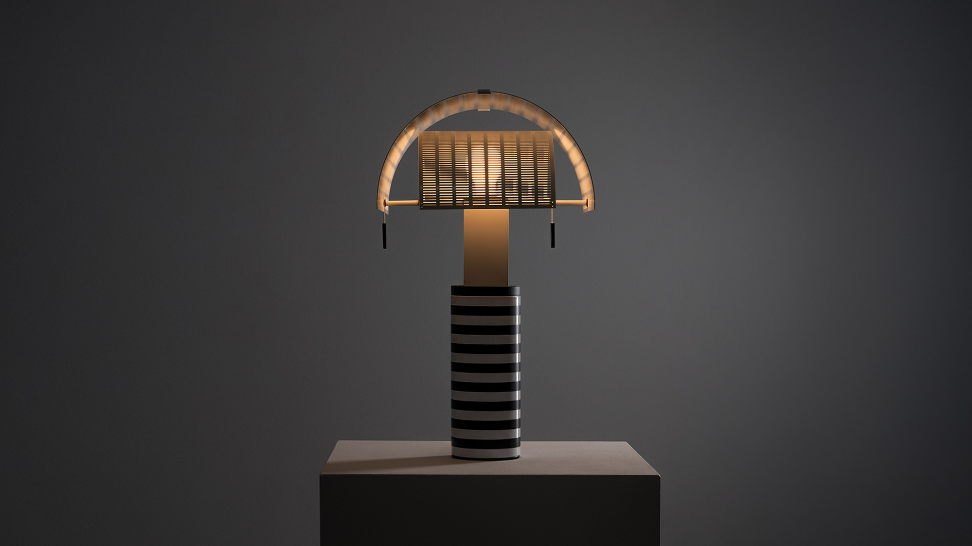 Soggiorno elegante con lampada da tavolo Artemide Shogun su tavolino, camino in marmo, poltrone bianche e barca a vela decorativa a parete