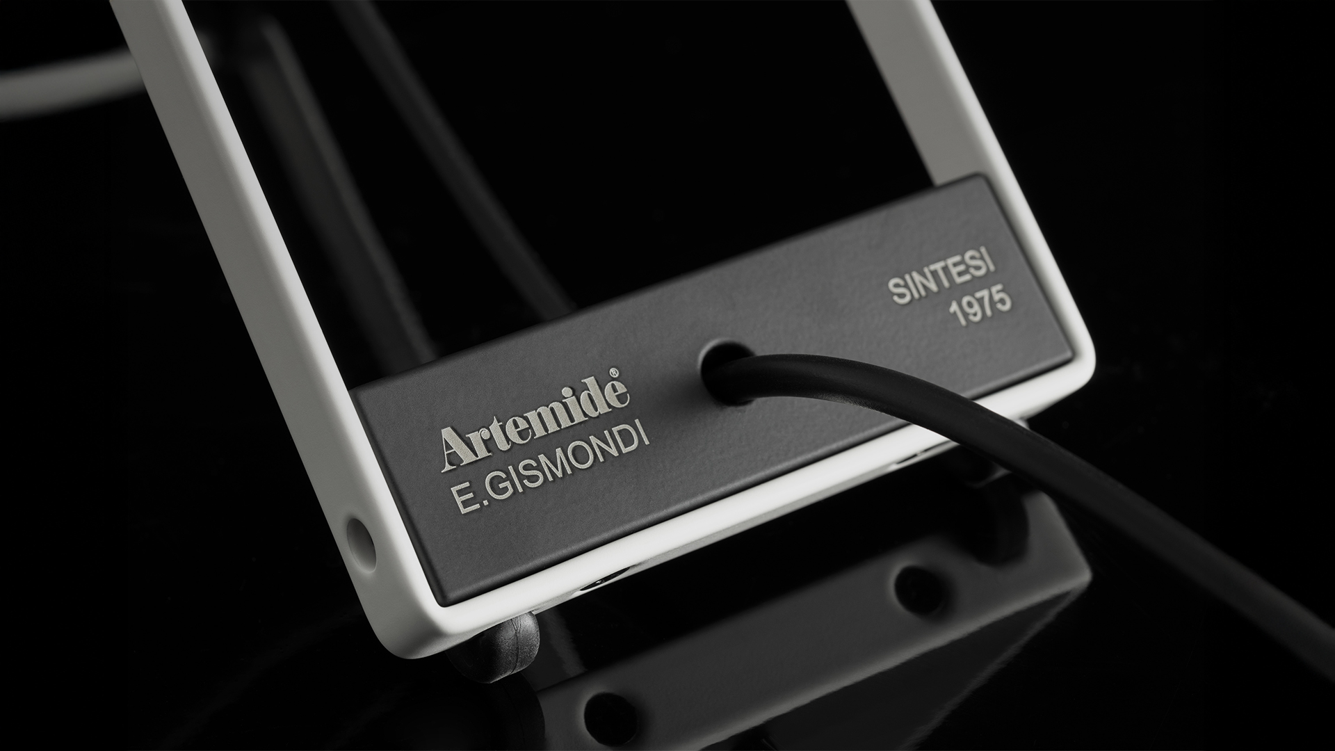 Due lampade da terra Artemide Sintesi: sinistra braccio rosso inclinato con paralume striato, destra struttura blu a cavalletto con diffusore illuminato