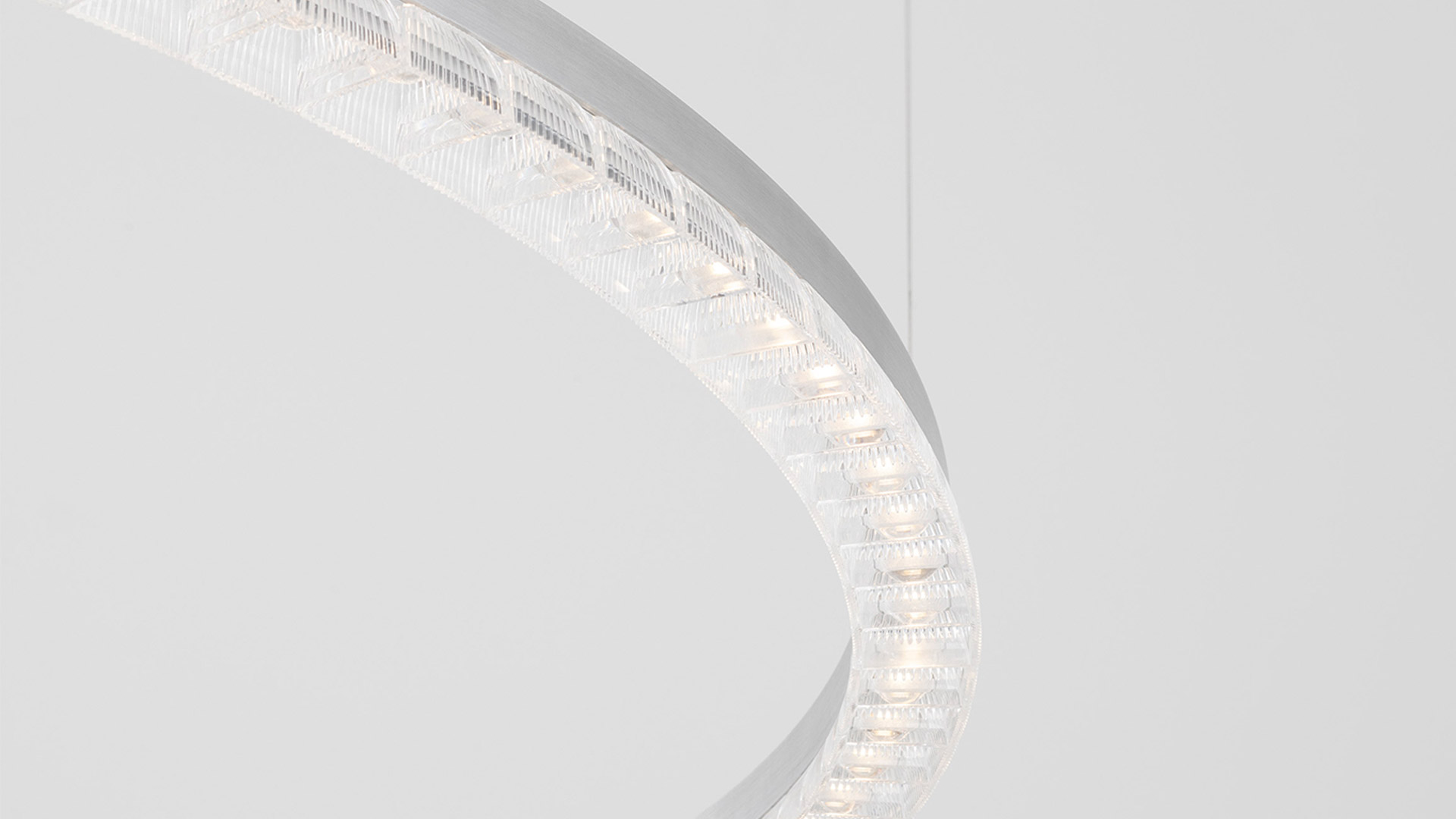Lampada a sospensione Artemide Somnĭum: primo piano dell'anello circolare con diffusori in cristallo strutturato e sorgenti LED calde su finitura bianca