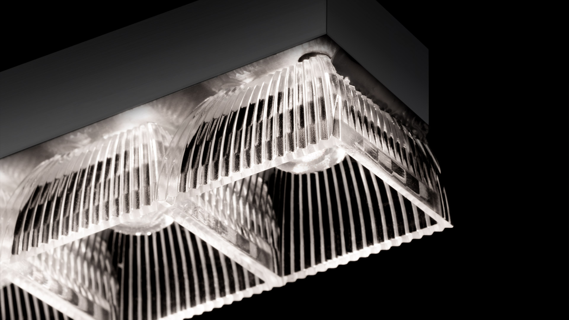 Lampada da soffitto Artemide Somnĭum Stand Alone con doppio diffusore nervato trasparente che emette luce bianca soffusa su sfondo scuro