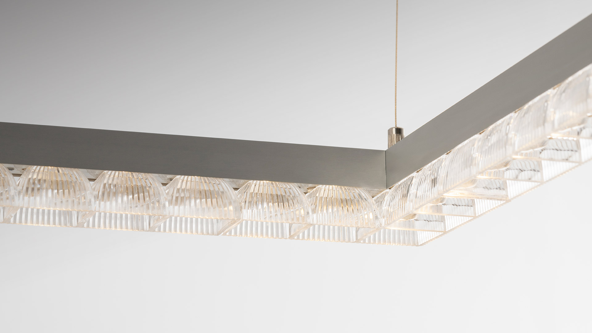 Artemide Somnium oval LED ring pendant lamp illuminating a dining room with tulip chairs and an oval white table