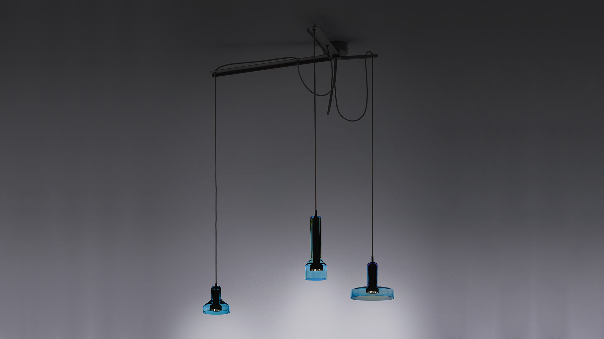 Tre lampade a sospensione Artemide Stablight in oro, blu e bronzo, con corpo cilindrico in vetro e base quadrata, appese a cavi neri