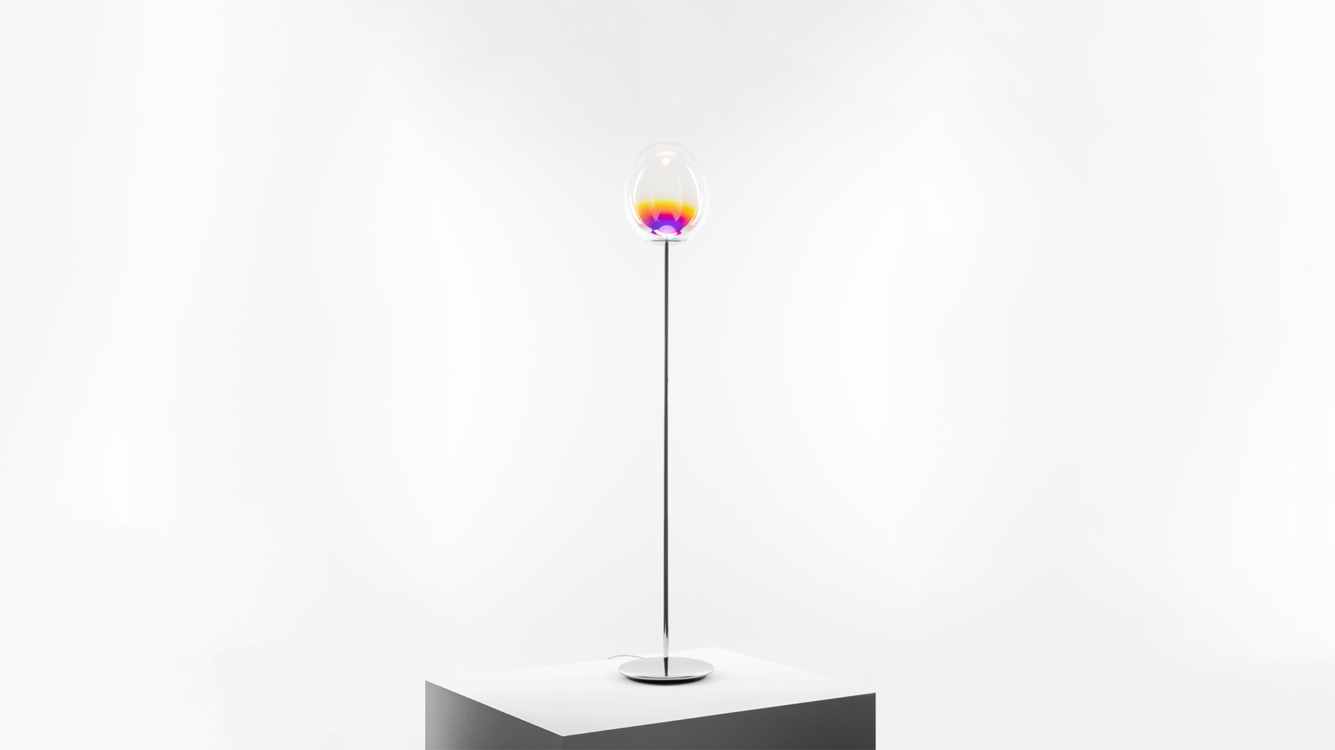 Bambina che soffia bolle di sapone accanto alle lampade a sospensione Artemide Stellar Nebula, i cui globi iridescenti imitano bolle fluttuanti