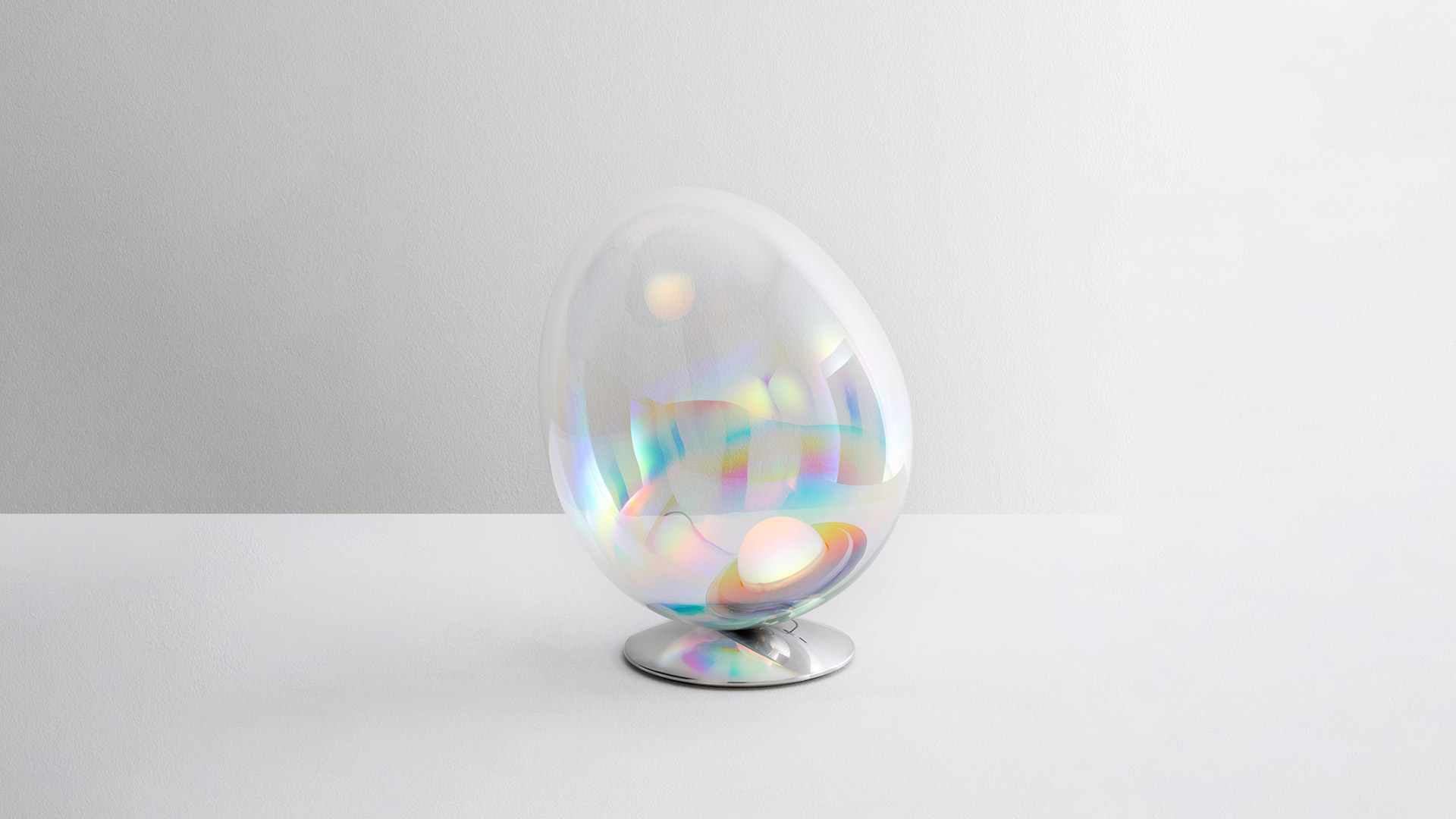 Lampada Artemide Stellar Nebula: diffusore trasparente iridescente a forma di uovo con riflessi arcobaleno su base cromata lucida