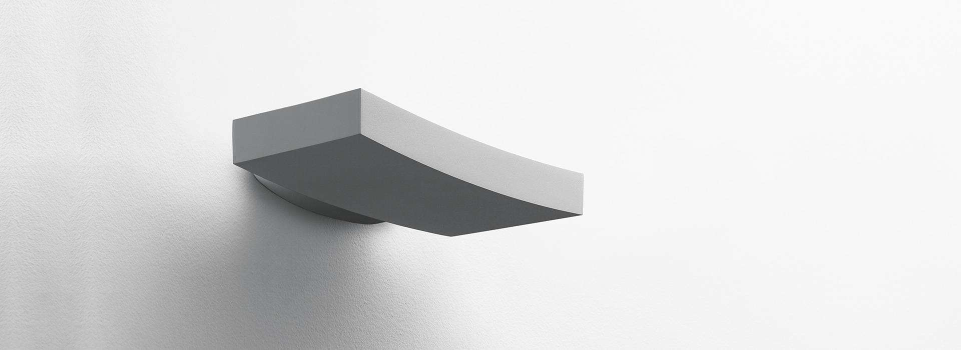 Artemide Surf Parete wall lamp: sleek curved rectangular white body with downward dark diffuser for indirect lighting