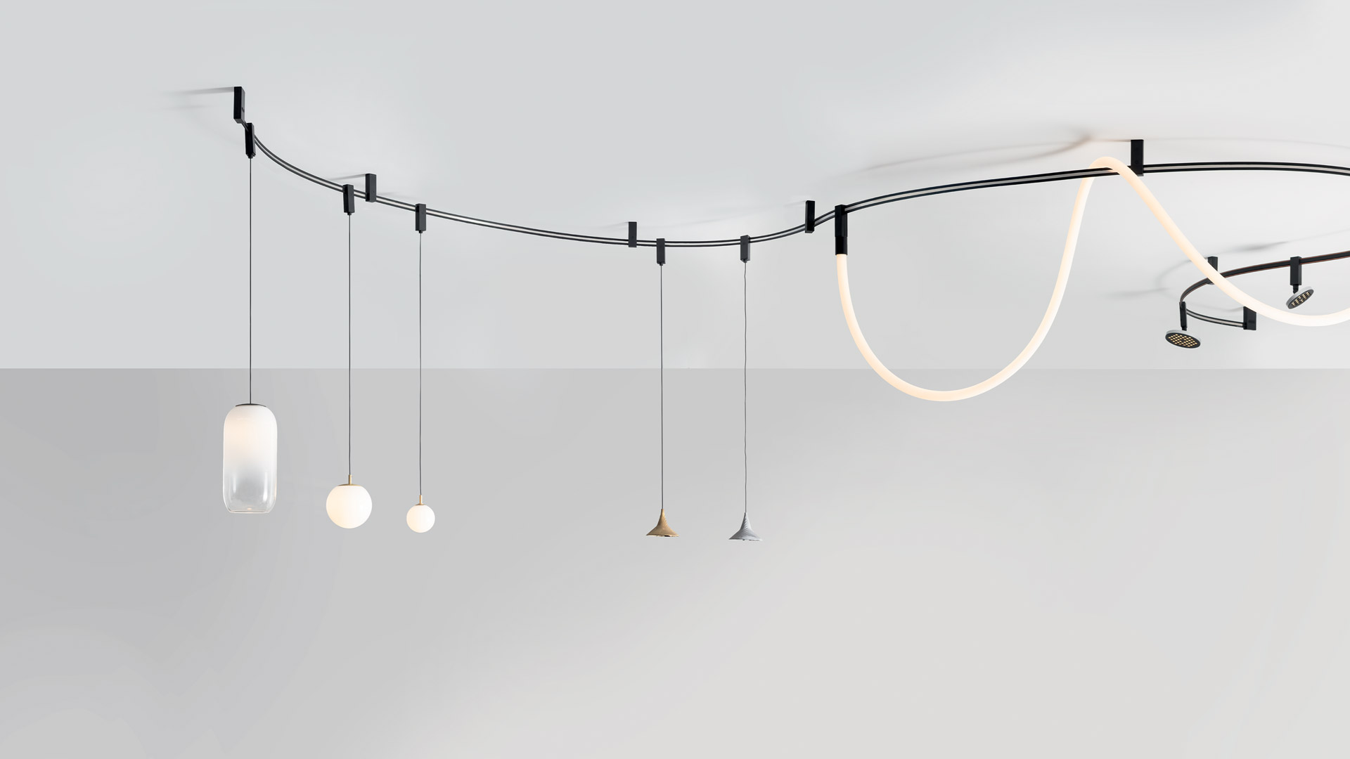 Primo piano del giunto della lampada Artemide Sylt: struttura rettangolare nera opaca con cavi intrecciati in rame che attraversano l'angolo