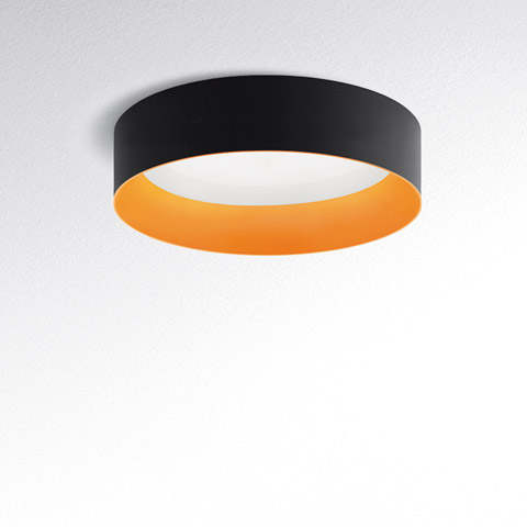 Plafoniera Tagora Soffitto 970 di Artemide: anello rotondo nero all'esterno con interno arancione caldo, luce LED bianca diffusa