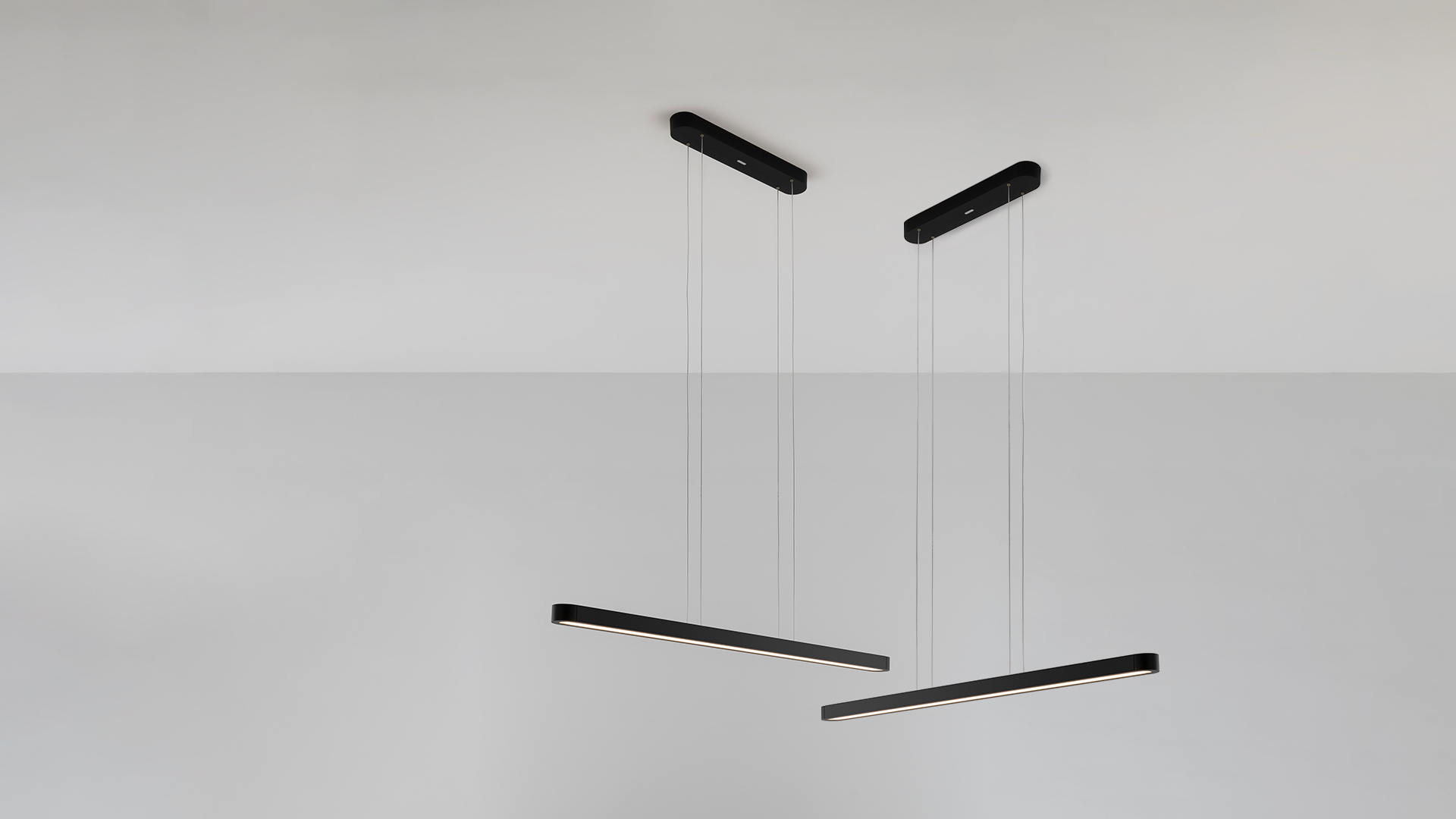 Lampada a sospensione Talo di Artemide: corpo lineare LED allungato nero con diffusore bianco caldo, sospeso da sottili cavi