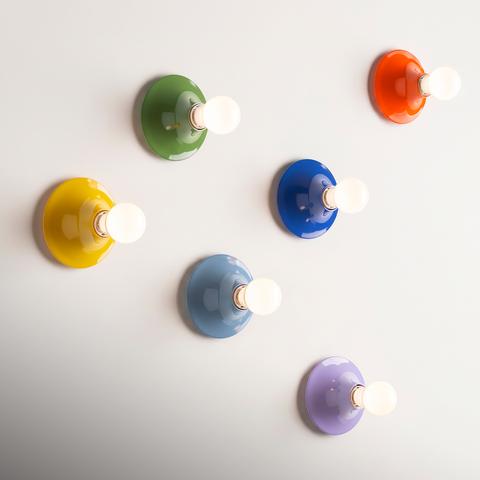 Sei applique da parete Artemide Teti in colori lucidi: giallo, verde, blu, azzurro, arancione e lavanda, ciascuna con lampadina a vista
