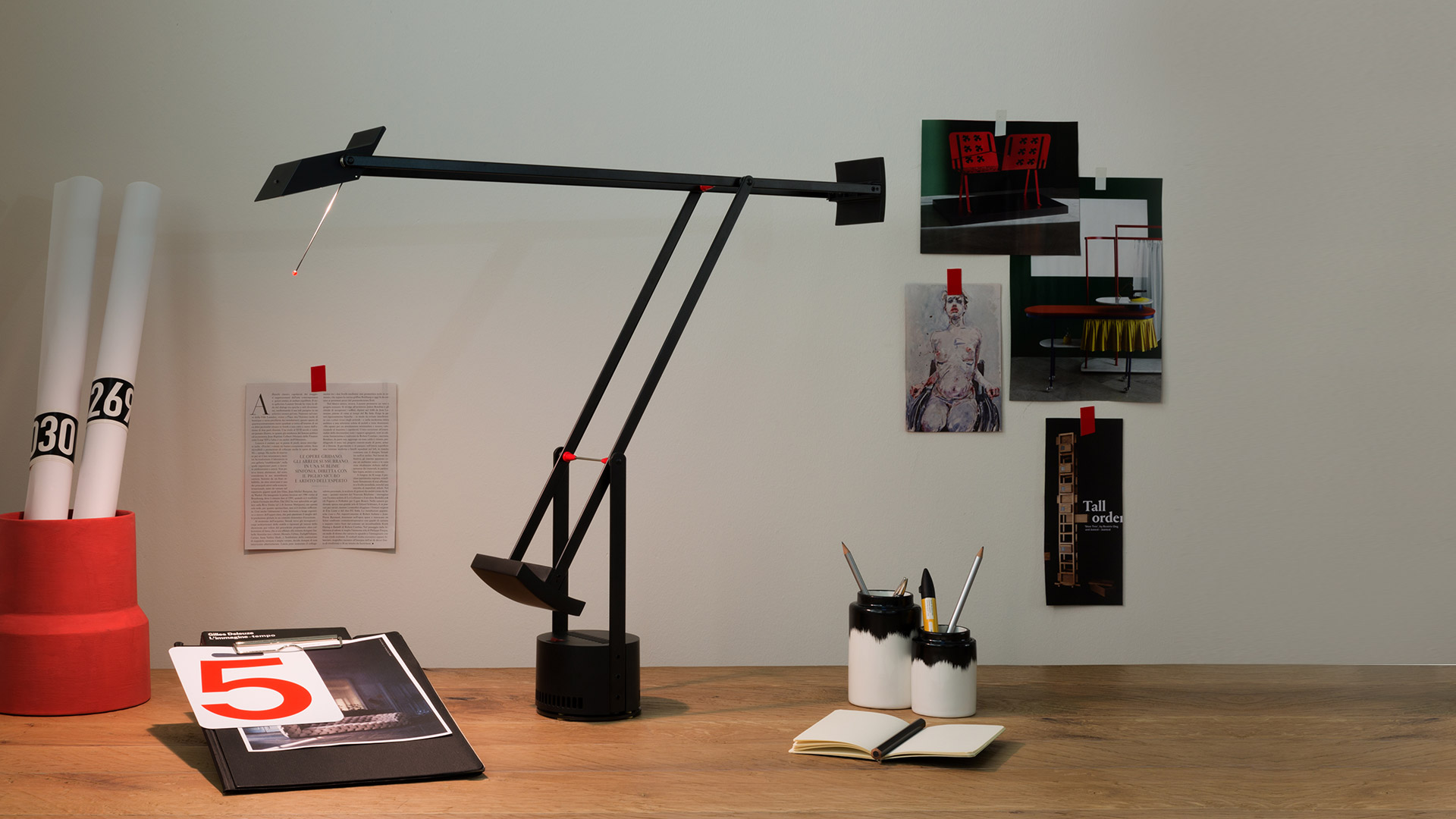 Tre lampade da terra Artemide Tizio in nero, con iconici bracci articolati regolabili e design a contrappeso, mostrate in varie posizioni