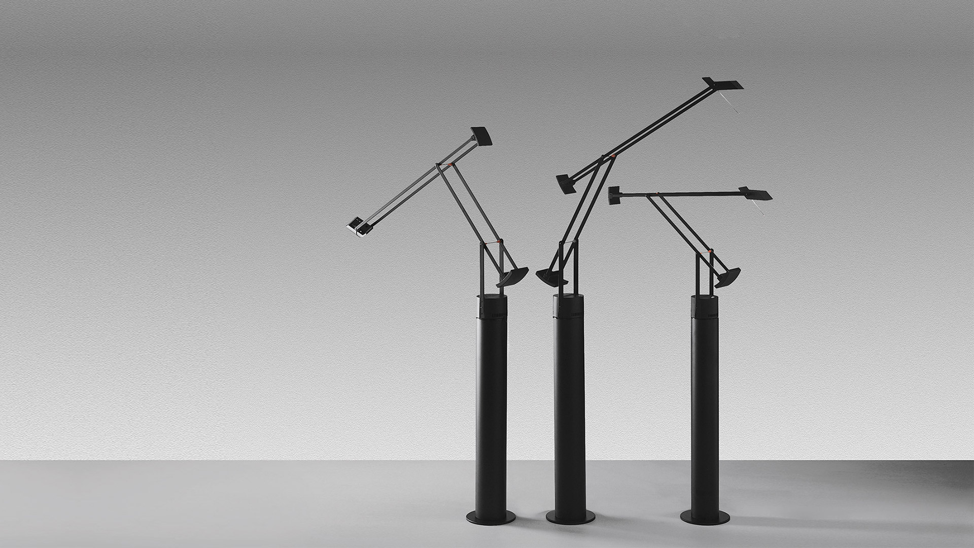 Lampada da tavolo Artemide Tolomeo su un tavolo riunioni bianco con sedie color cuoio in uno studio luminoso in stile scandinavo con grande finestra