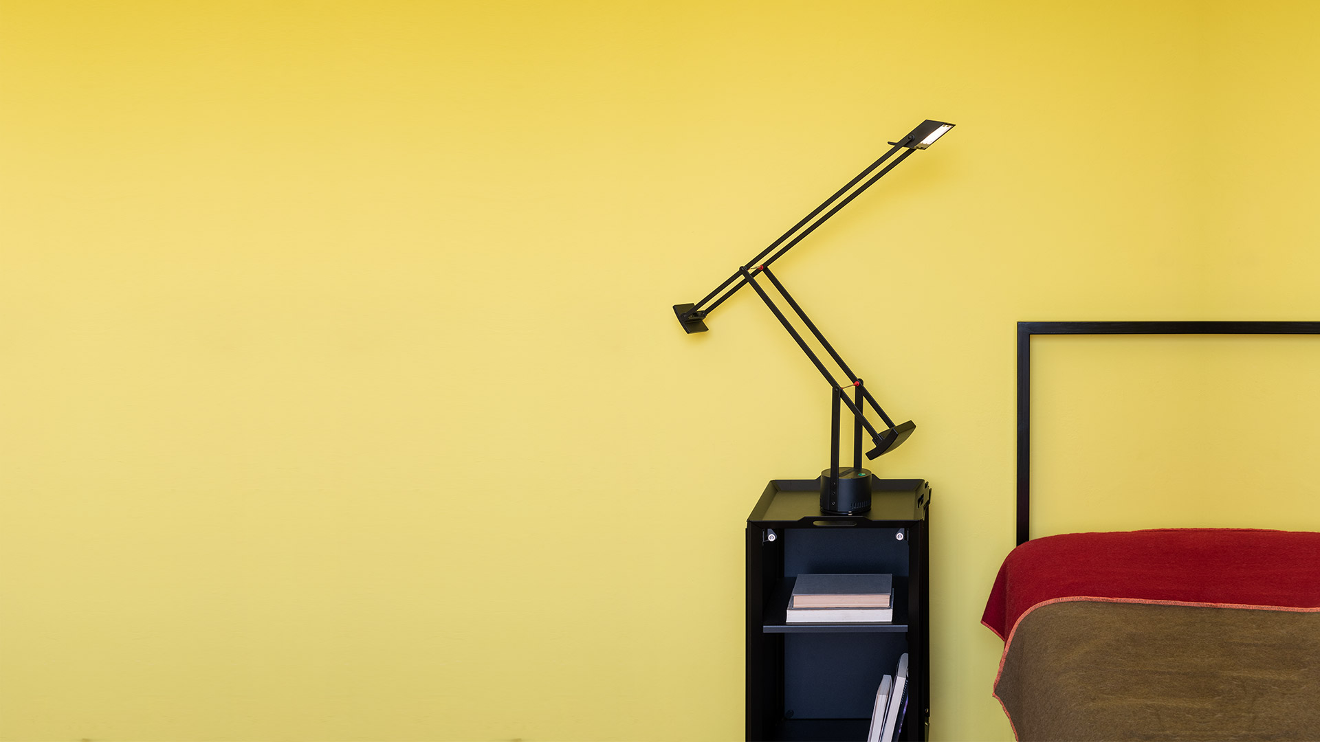 Tre lampade da tavolo Artemide Tizio in nero, bianco e grigio scuro, con il loro iconico design a braccio articolato controbilanciato.