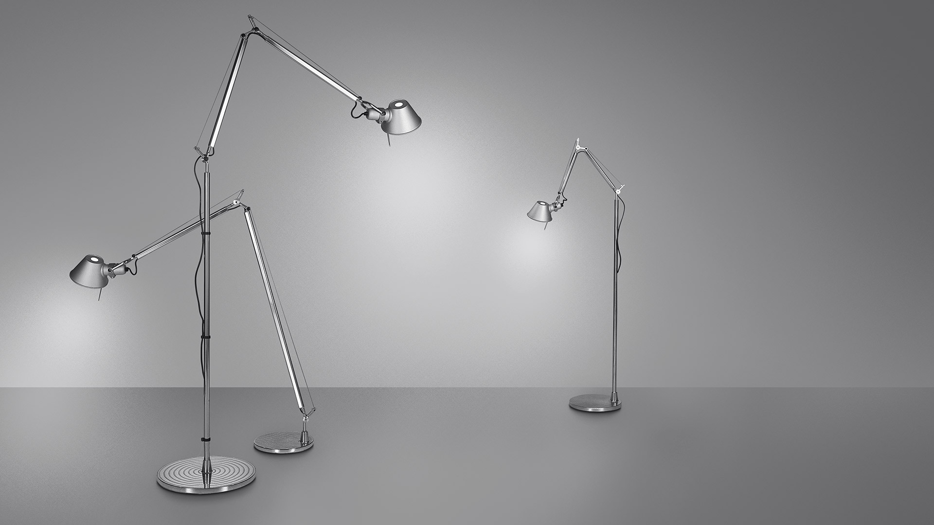 Due lampade da terra Artemide Tolomeo Terra in alluminio lucido con bracci articolati regolabili e paralumi conici su basi rotonde