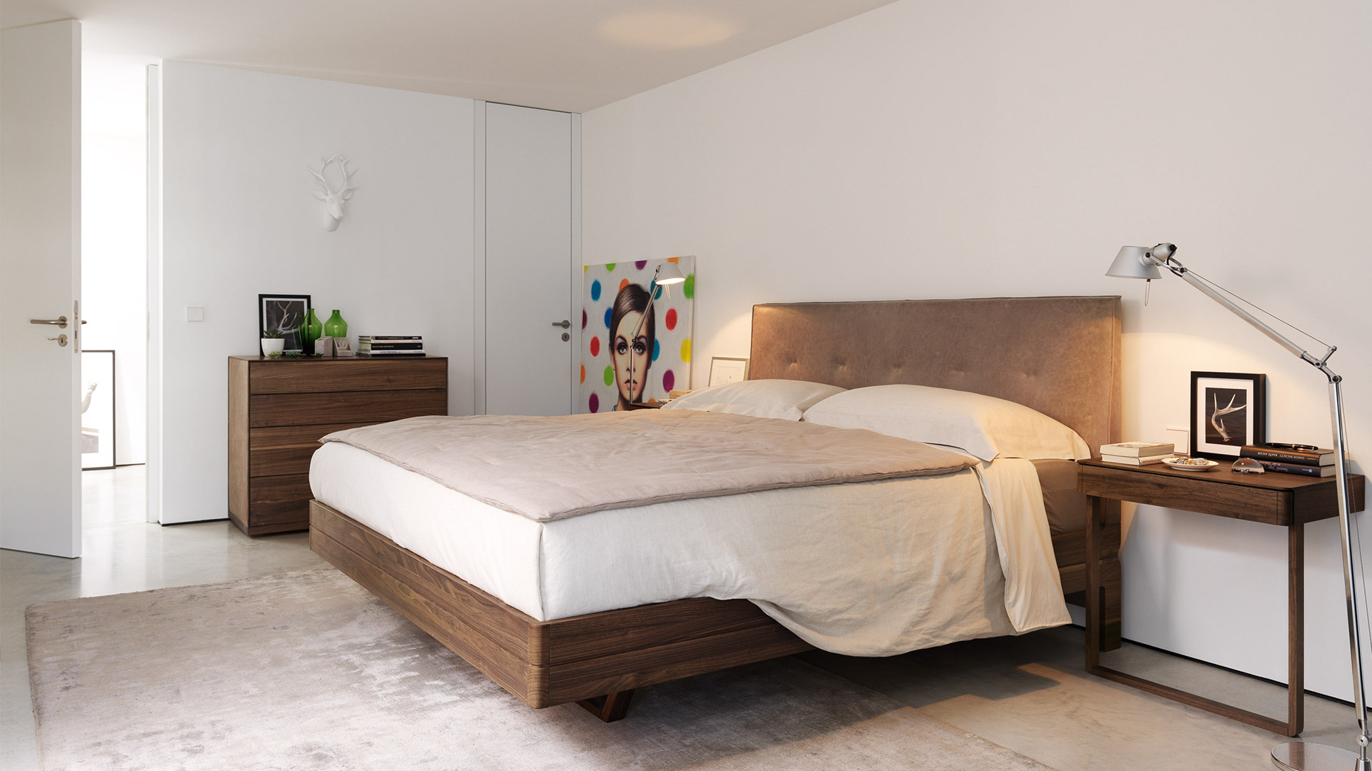 Camera da letto moderna con lampada da terra Artemide Tolomeo Terra accanto a un letto in noce, che illumina il comodino