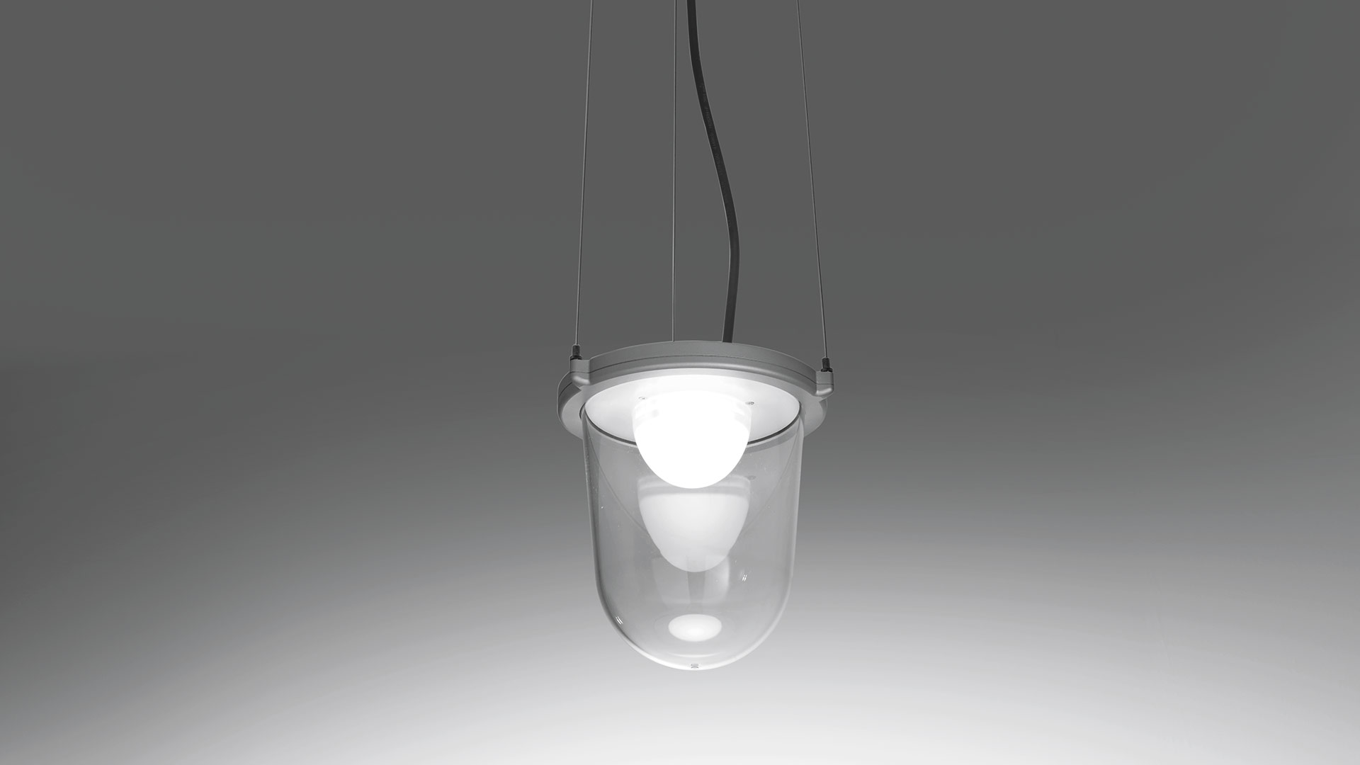 Lampada da parete Artemide Tolomeo Lampione Outdoor: braccio in alluminio con paralume a campana in vetro trasparente con bulbo LED sferico, montata su parete bianca