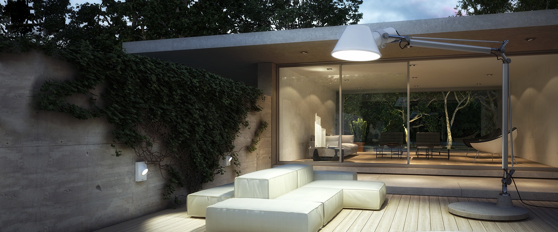 Interno di loft industriale con scale in legno, ringhiere nere, colonne in cemento e lampada da terra Artemide Tolomeo XXL Outdoor a sinistra