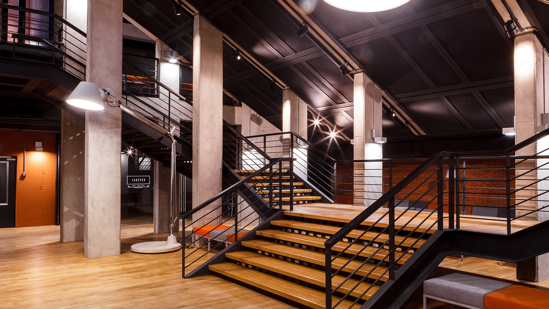 Lampada da terra Artemide Tolomeo XXL Outdoor di grandi dimensioni in bianco, esposta in un'installazione esterna brandizzata rossa con piante.