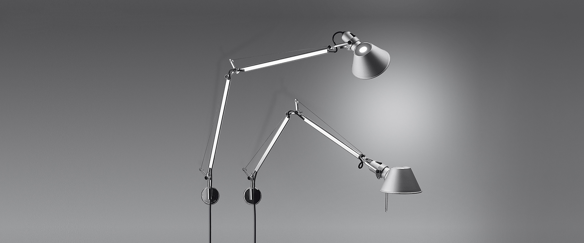 Due lampade da parete Artemide Tolomeo Parete in alluminio, con bracci articolati e paralumi regolabili, montate su sfondo grigio