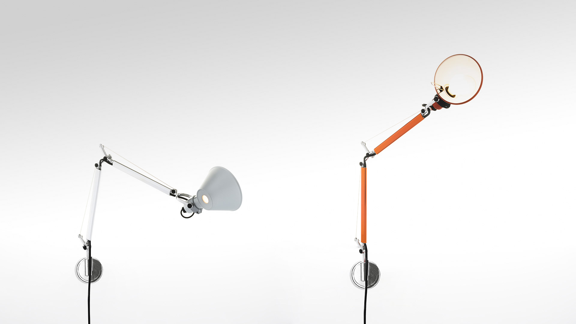 Due lampade da parete Artemide Tolomeo: sinistra bianca con paralume conico, destra arancione con diffusore circolare, entrambe su bracci articolati regolabili