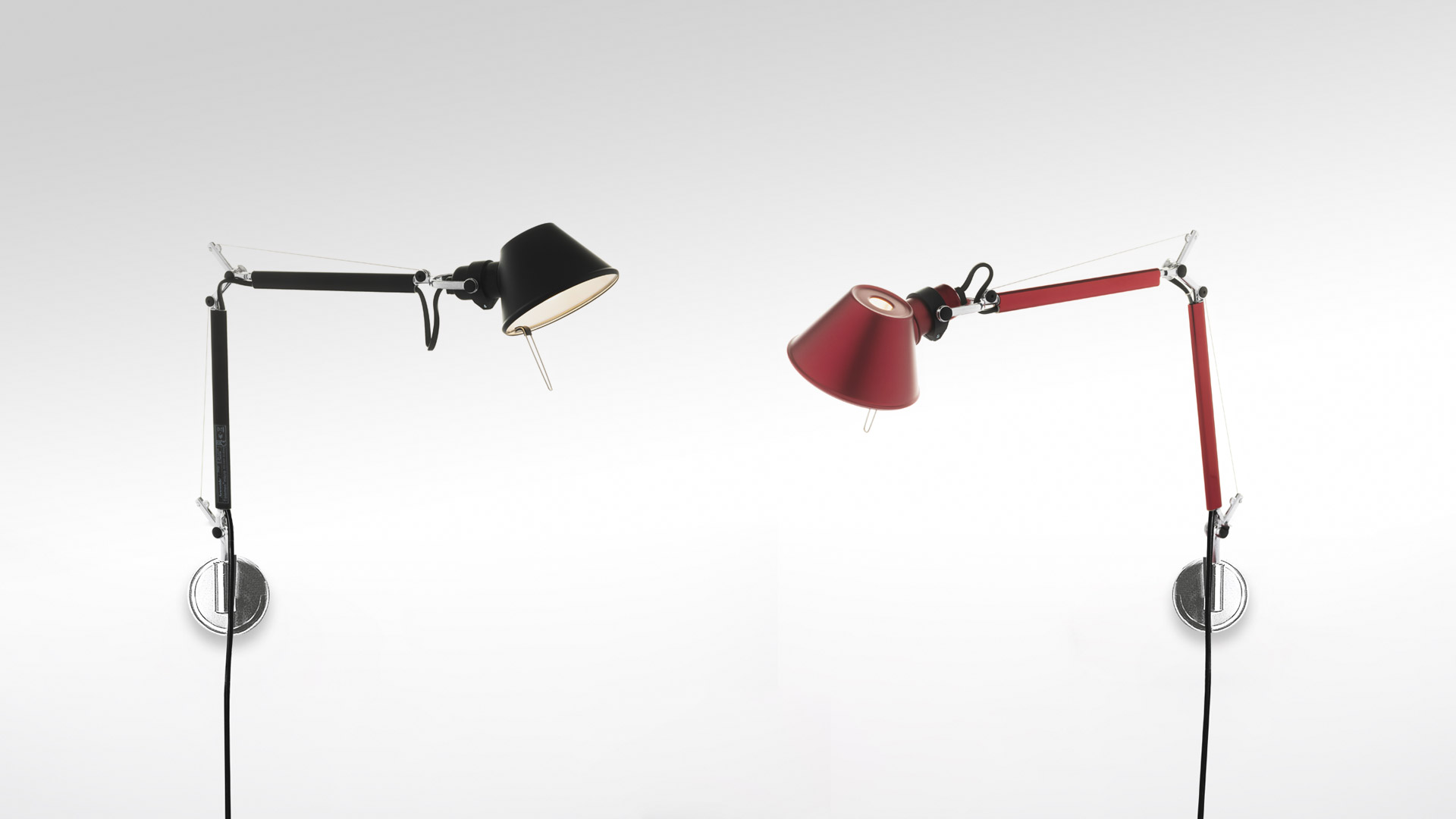 Due lampade da parete Artemide Tolomeo Micro Parete: sinistra in nero, destra in rosso, entrambe con bracci articolati regolabili e paralumi conici