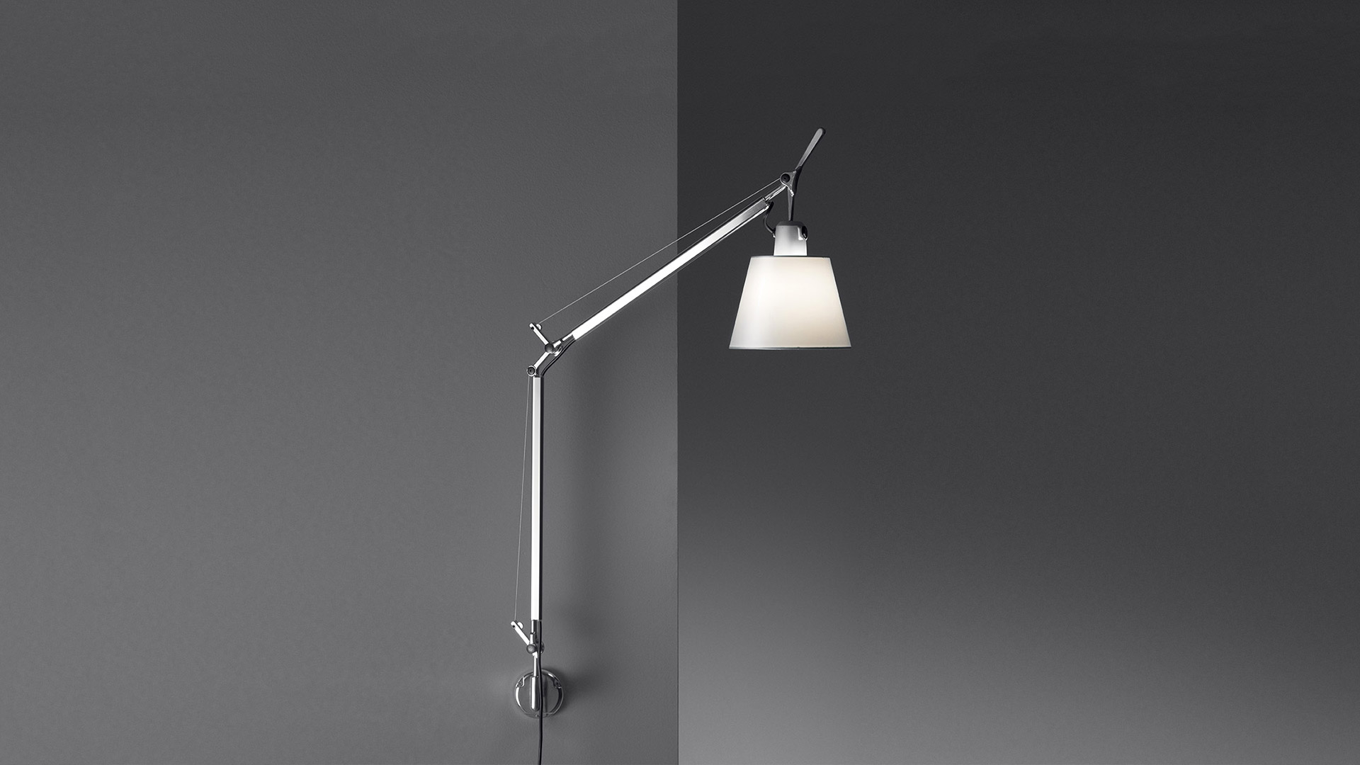 Artemide Tolomeo Basculante Parete wall lamp with adjustable aluminum arm and white conical fabric shade, mounted on wall