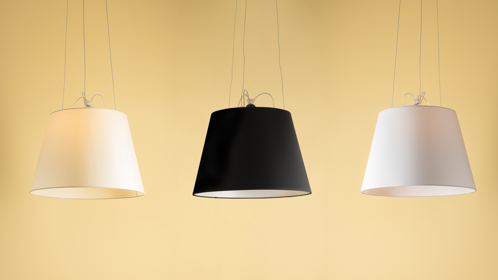 Tre lampade a sospensione Artemide Tolomeo Mega Sospensione: due bianche e una nera, con paralumi conici in tessuto su sottili cavi