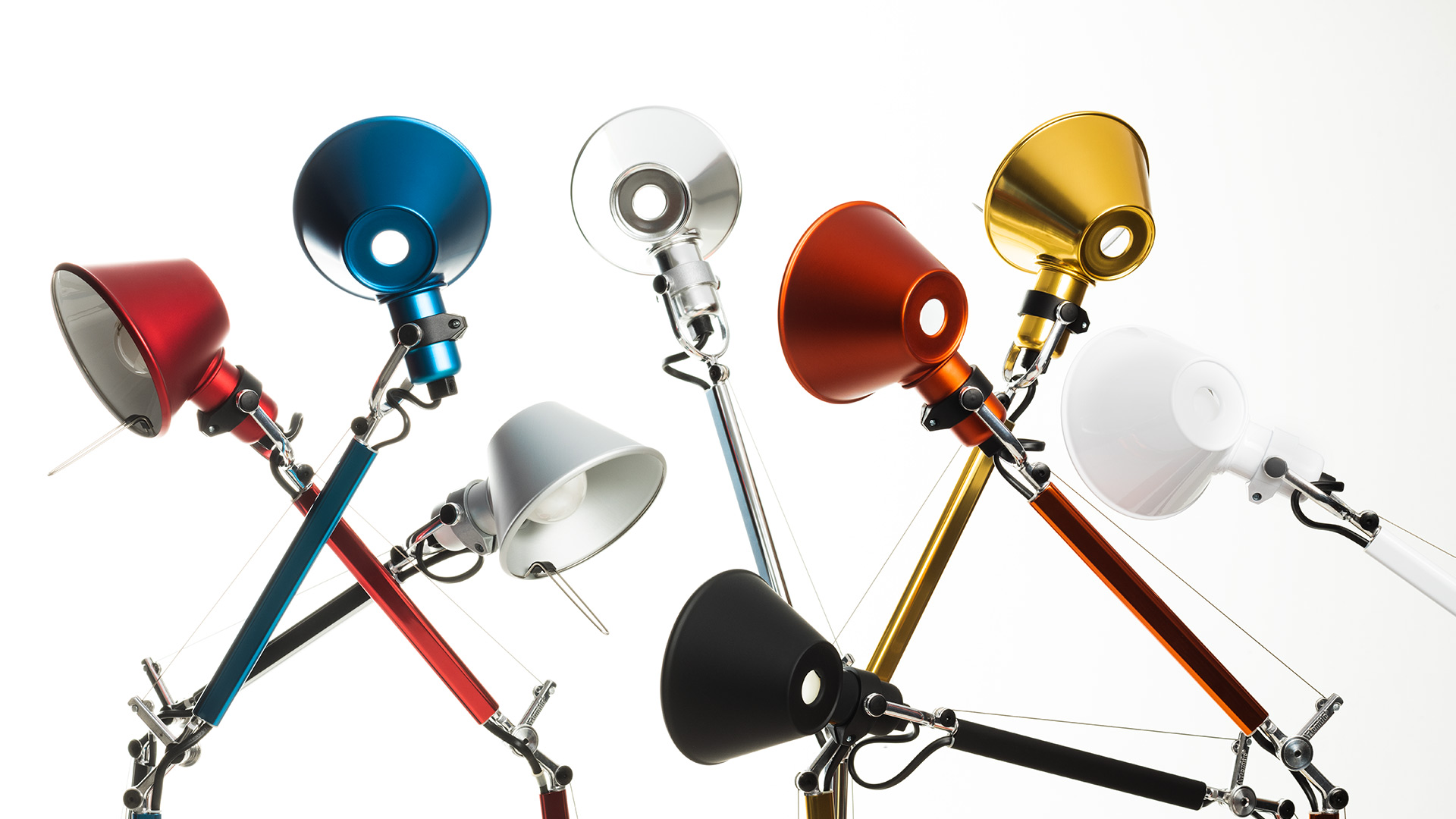 Five Artemide Tolomeo Micro table lamps in green, light blue, yellow, blue, and lavender, with adjustable arms and cone shades