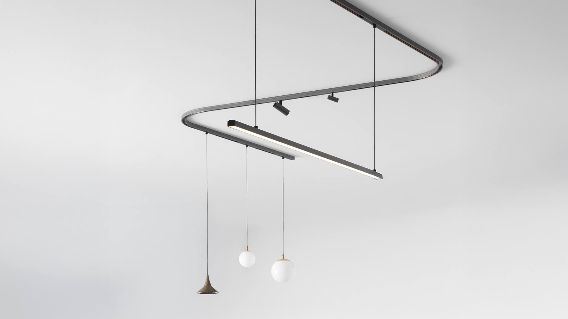 Artemide Turn Around System: binario LED lineare curvo in argento e nero, con moduli LED direzionali regolabili lungo una guida elegante