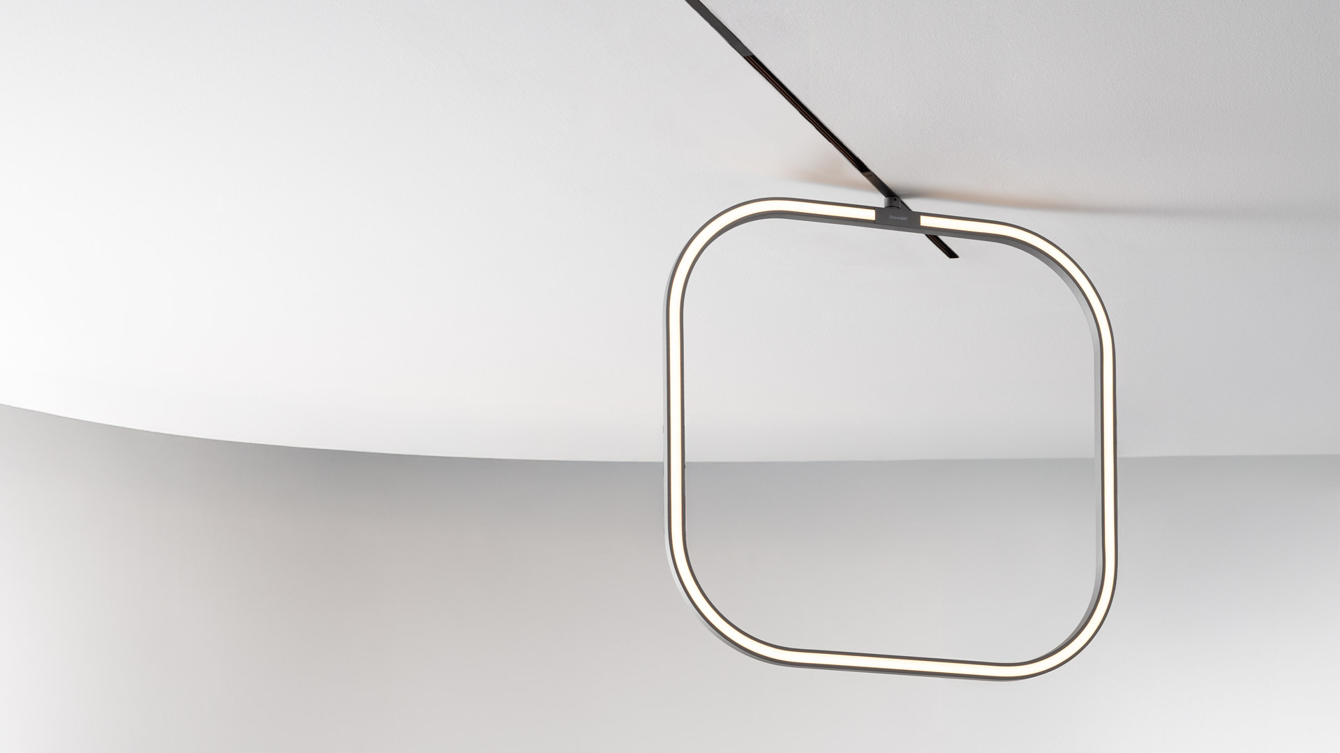 Artemide Turn Around System: binario curvo scuro sospeso al soffitto con faretti, barra LED lineare e tre lampade a sospensione