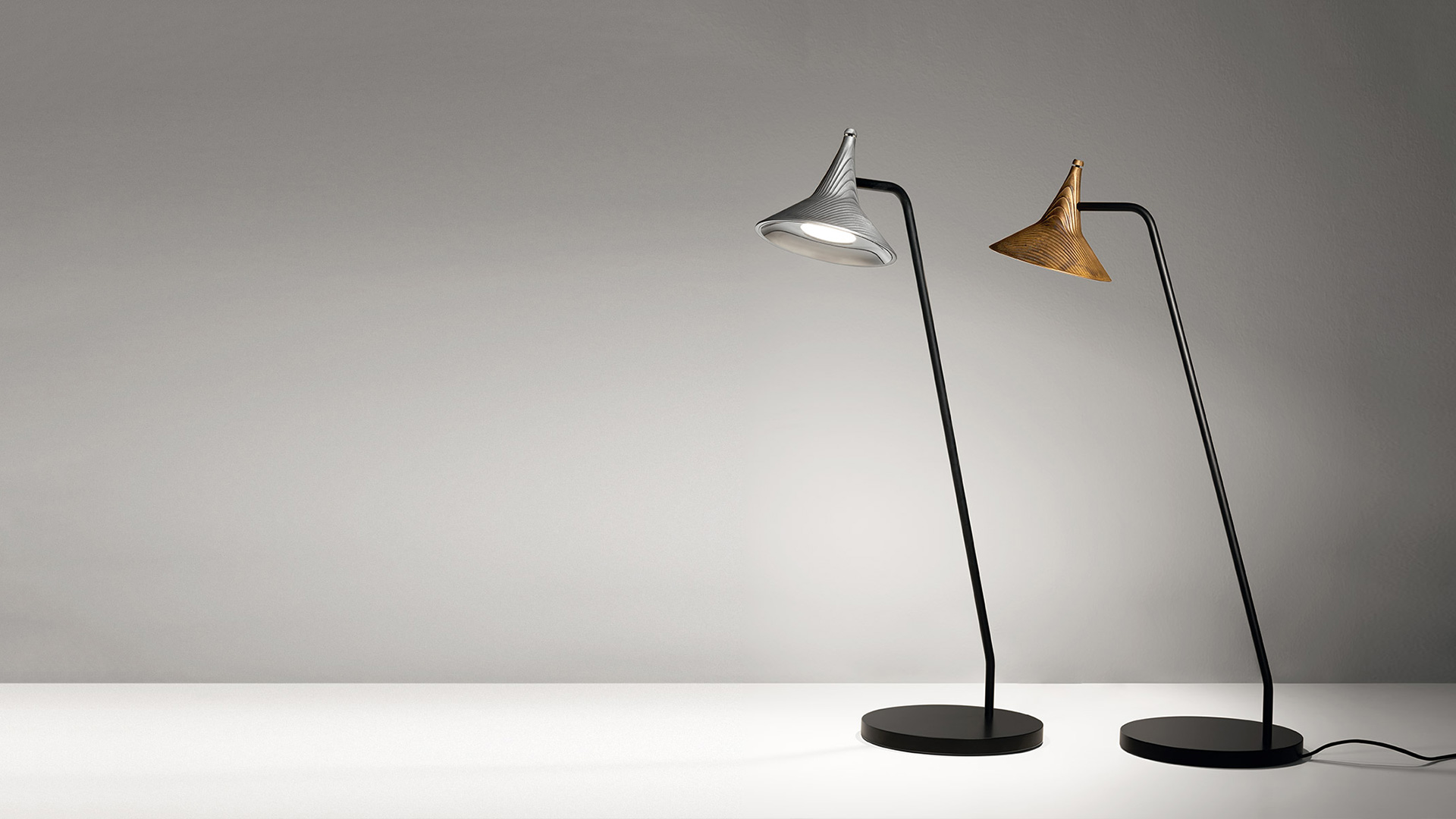 Lampadario Artemide Unterlinden: anello circolare nero con cinque pendenti a cono in ottone appesi da cavi neri a una rosetta a soffitto