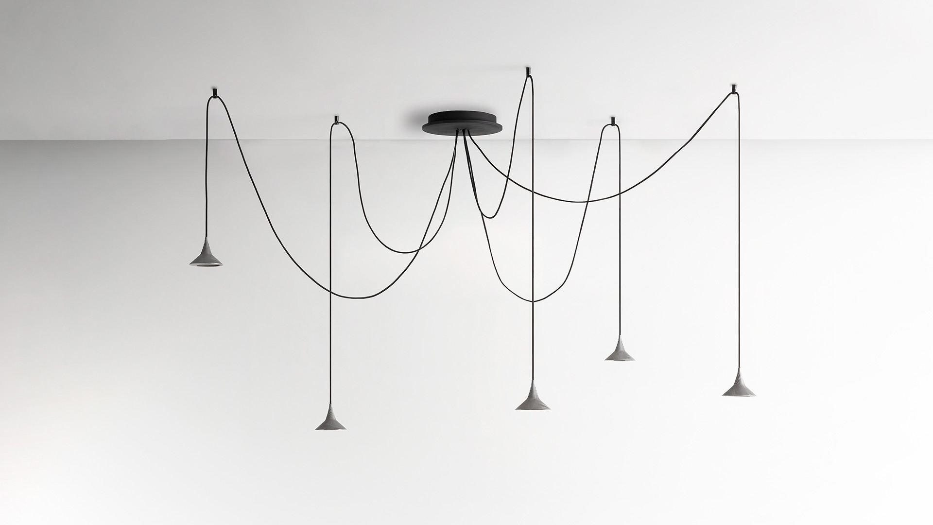 Lampada a sospensione Unterlinden di Artemide: paralume svasato finitura ottone con texture concentrica, emette luce calda verso il basso da anello LED