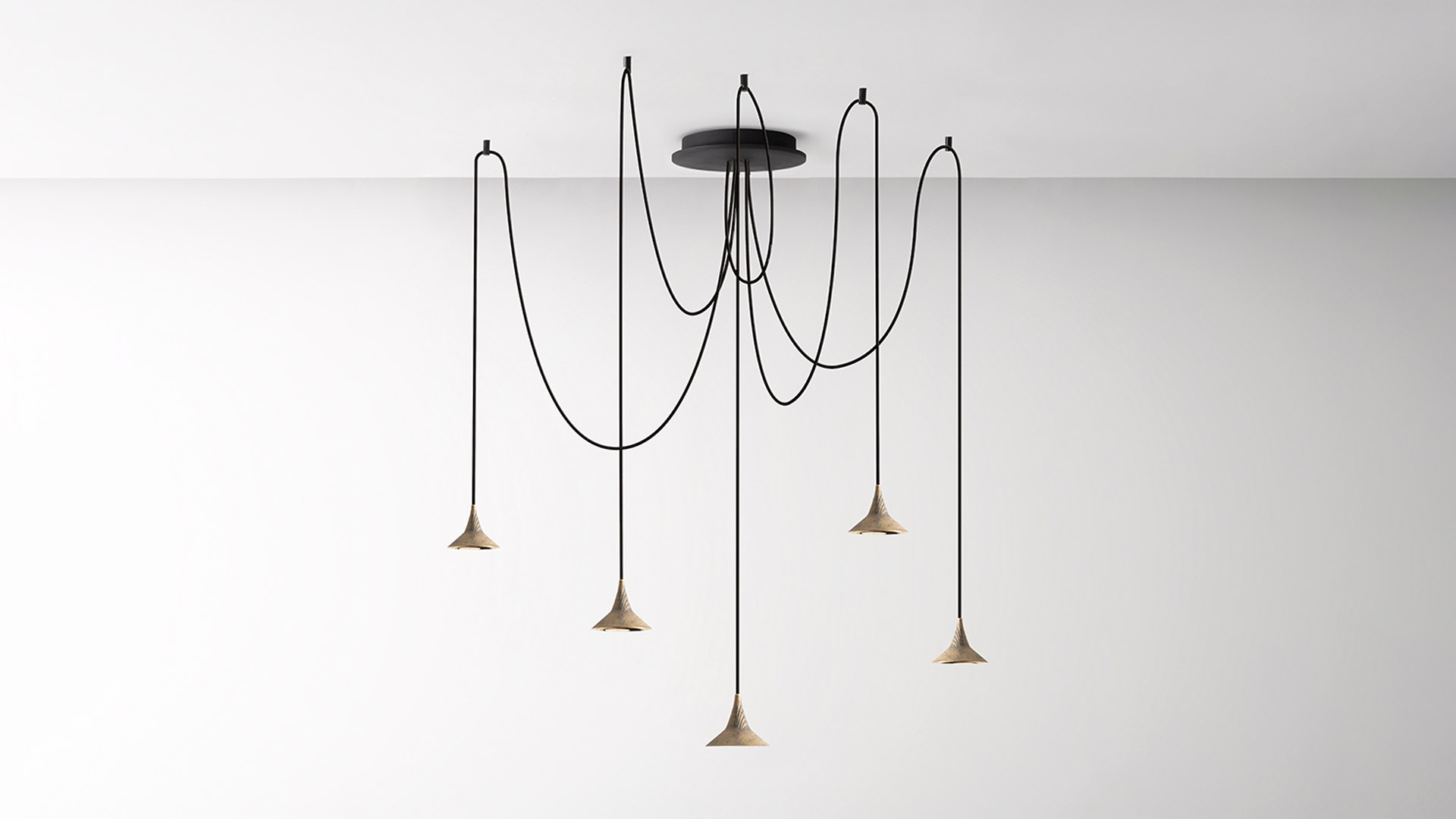 Lampada da tavolo Unterlinden di Artemide: finitura opaca scura, stelo inclinato, paralume conico che diffonde luce calda su una scrivania minimalista