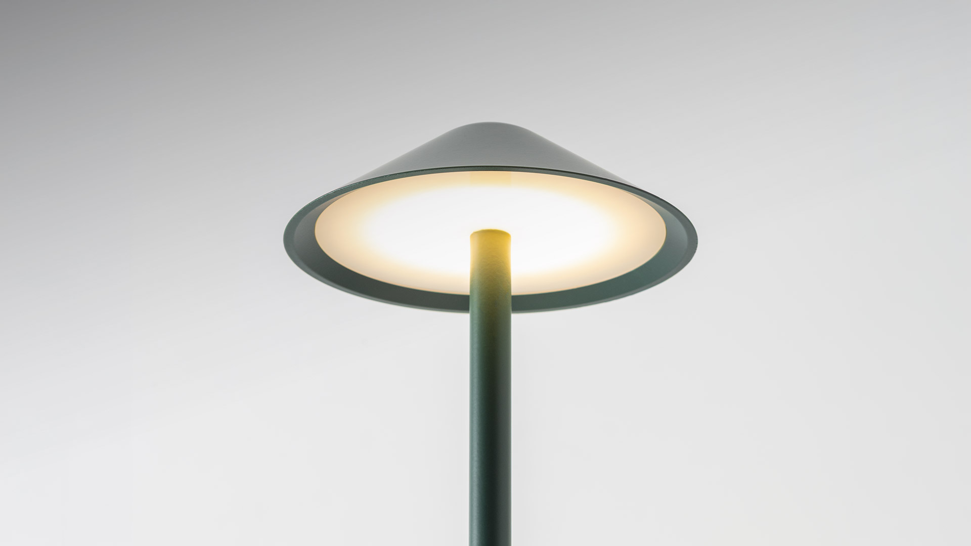 Lampada da esterno Artemide Vea Bollard in verde salvia, con ampio paralume conico su un esile fusto cilindrico