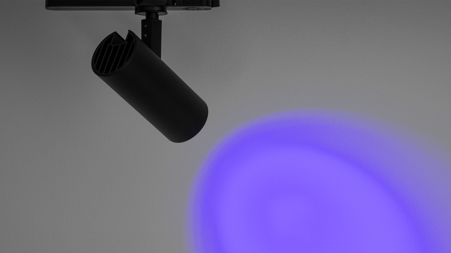 Tre faretti Artemide Vector Track 230V su binario: teste cilindriche nera, bianca e argento, orientamento regolabile