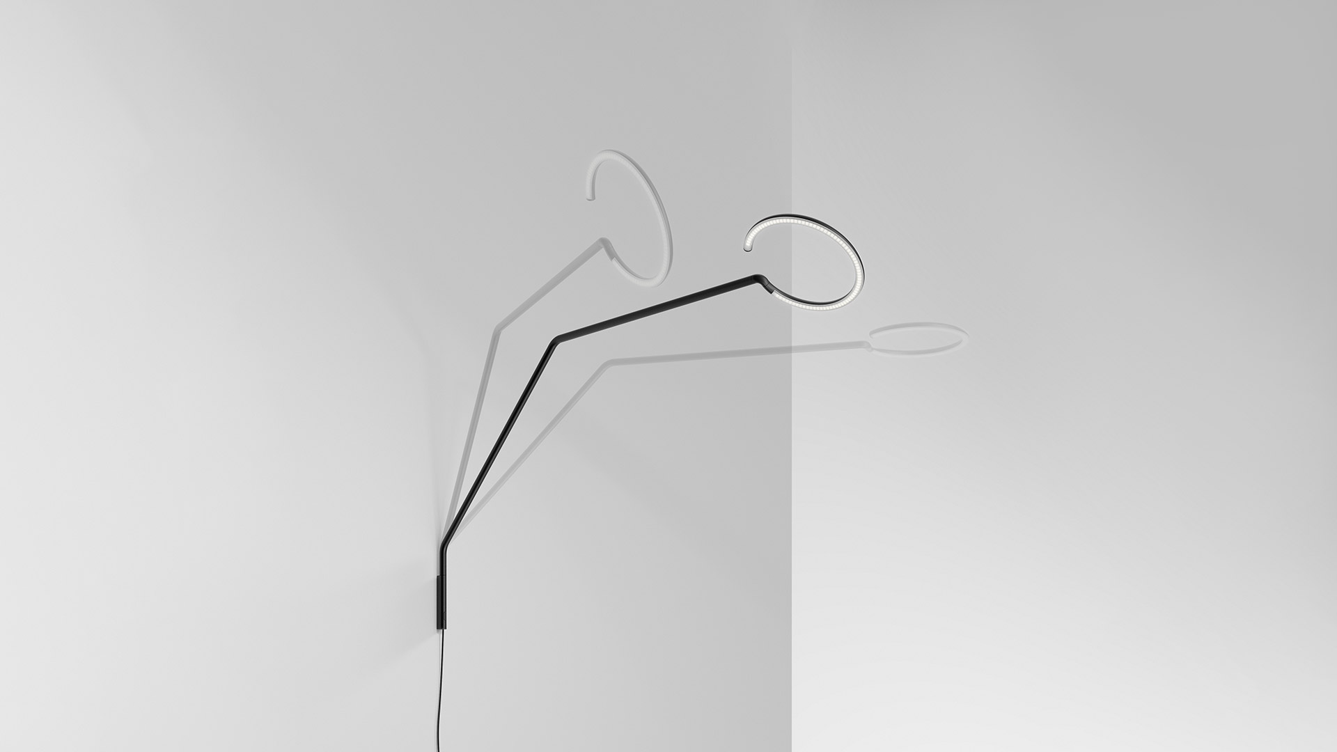 Artemide Vine Light table lamp in black with circular LED ring head on angled arm, placed on a wooden table beside an open book