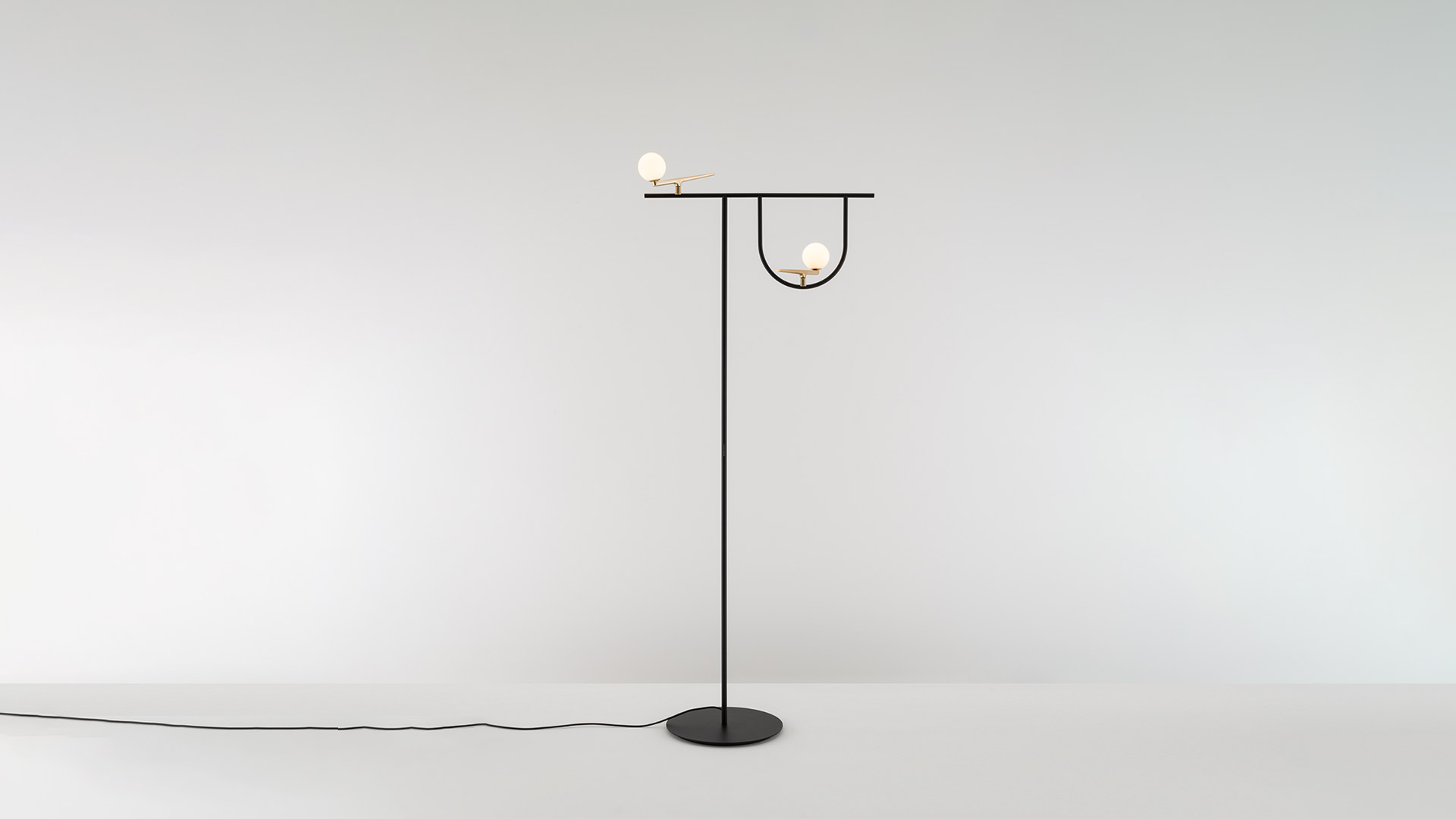 Artemide Yanzi pendant lamp with glass dome and small sphere diffuser on black frame, hanging in a bright Scandinavian-style room
