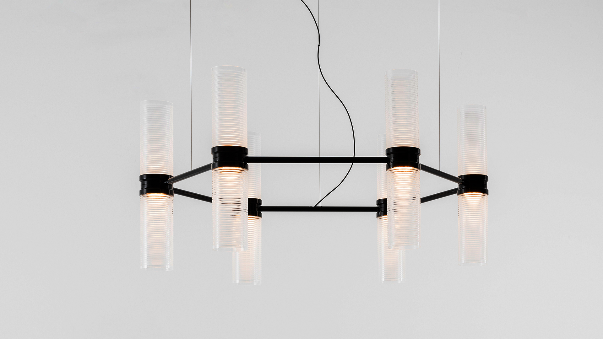 Lampada a sospensione Artemide Zephyr: sei diffusori cilindrici verticali in vetro montati su una barra metallica orizzontale color bronzo scuro