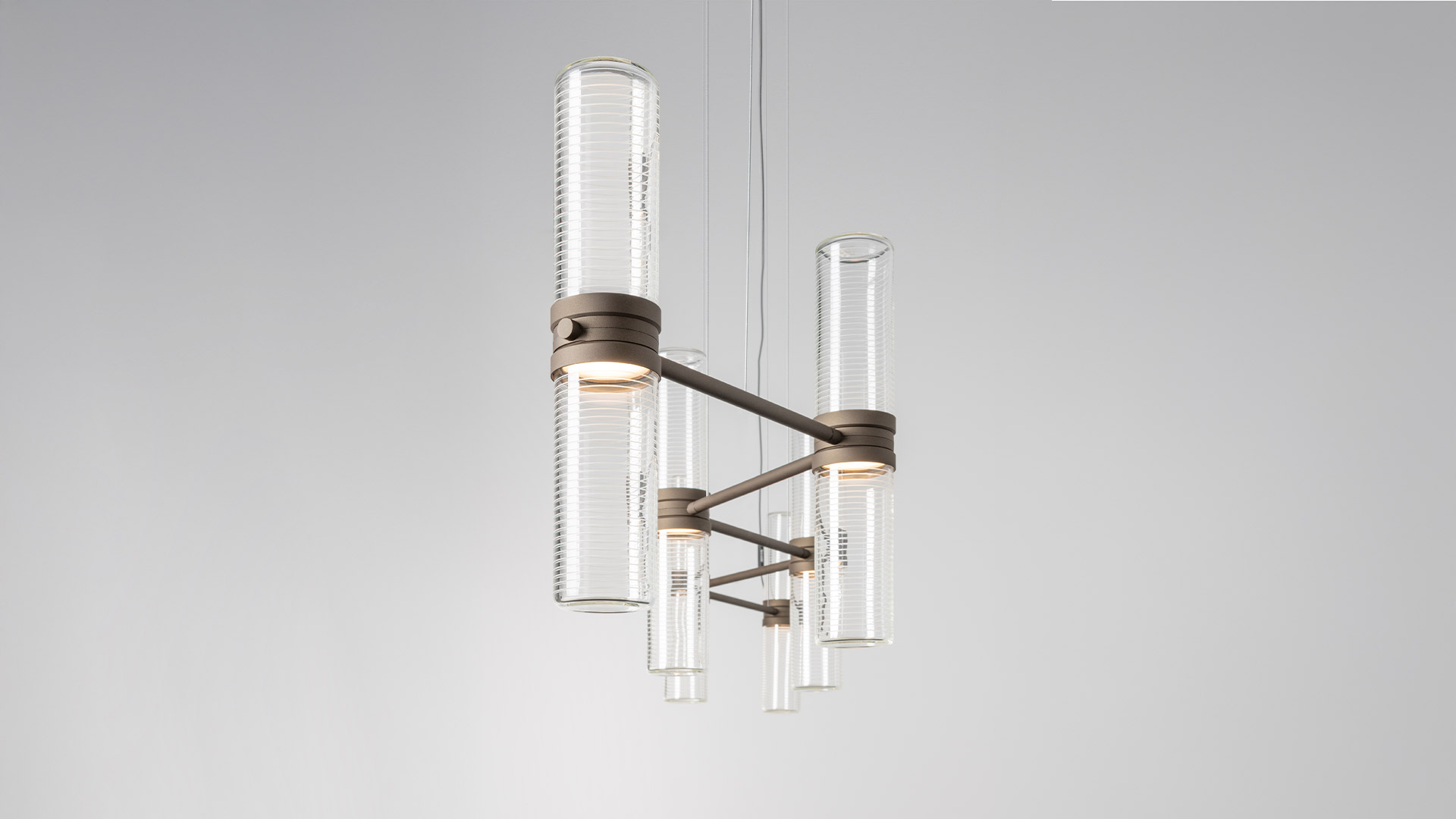Lampadario Artemide Zephyr: bracci neri opachi con diffusori cilindrici in vetro costolato rivolti verso il basso, design moderno ed elegante